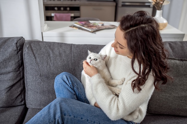 Fine settimana. Giovane donna sveglia che trascorre il fine settimana a casa con il suo gatto