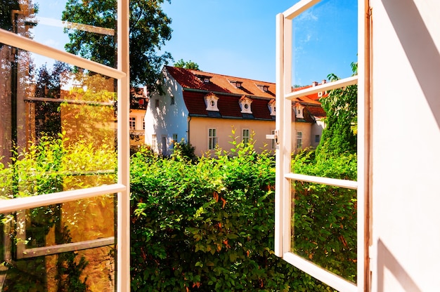 Finestra aperta e vista del giardino estivo nella Città Vecchia di Praga, Repubblica Ceca.
