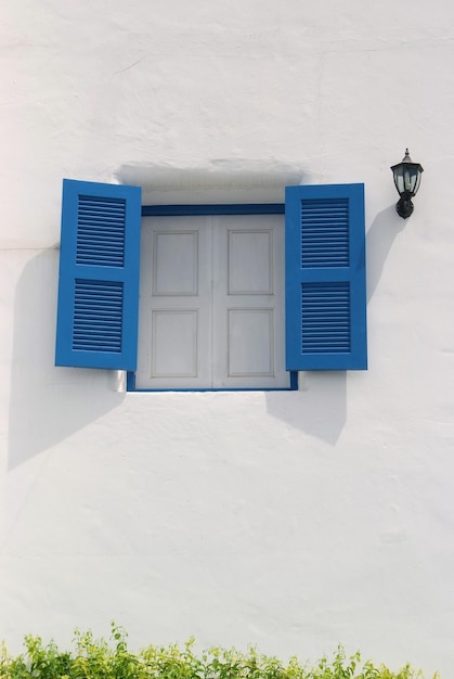 Finestra blu vintage sul muro bianco