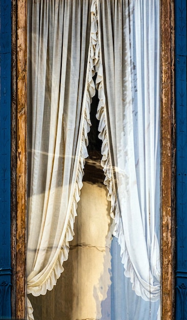Finestra in legno modernista con la sua tenda splendidamente ricamata in una casa a Granollers
