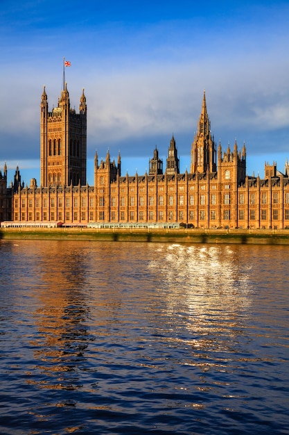 Finestre del Palazzo di Westminster che riflettono nel fiume Tamigi Londra UK