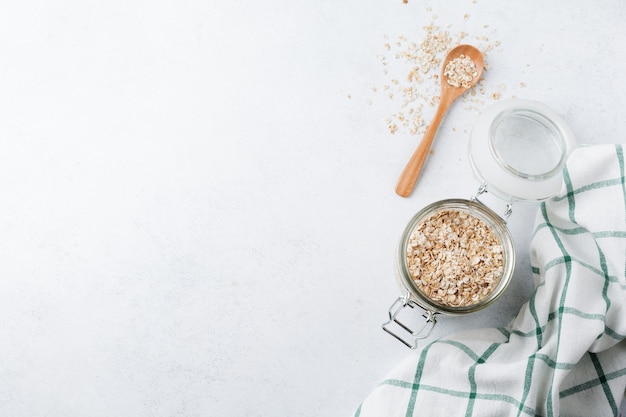 Fiocchi d'avena crudi in un barattolo di vetro su una luce.