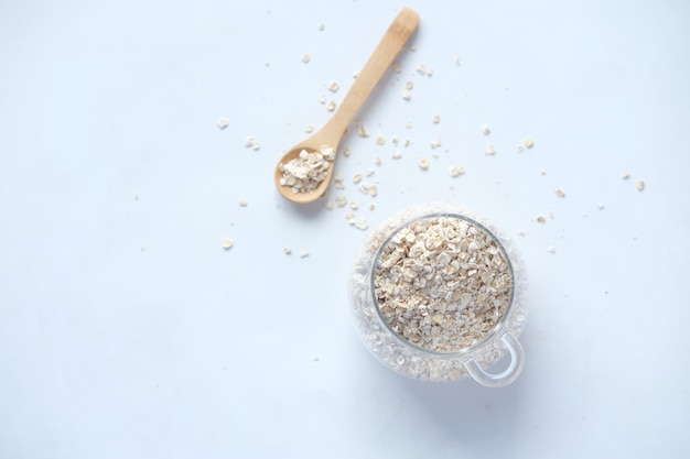 Fiocchi d'avena in un barattolo con cucchiaio sul tavolo.