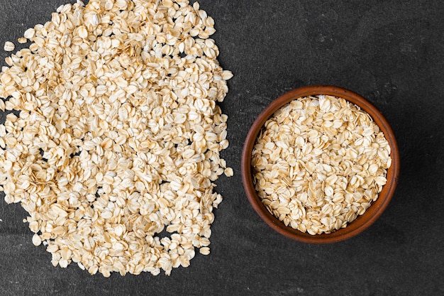 Fiocchi d'avena in una ciotola sul vecchio bordo Mangiare sano