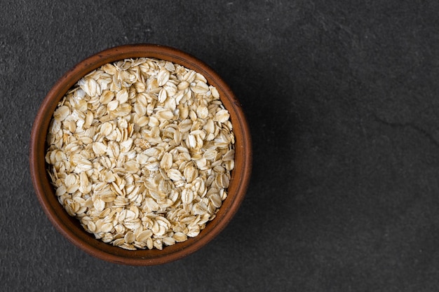 Fiocchi d'avena in una ciotola sul vecchio bordo Mangiare sano