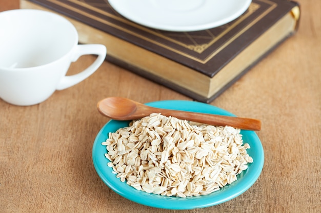 Fiocchi di avena nel piatto sul tavolo di legno