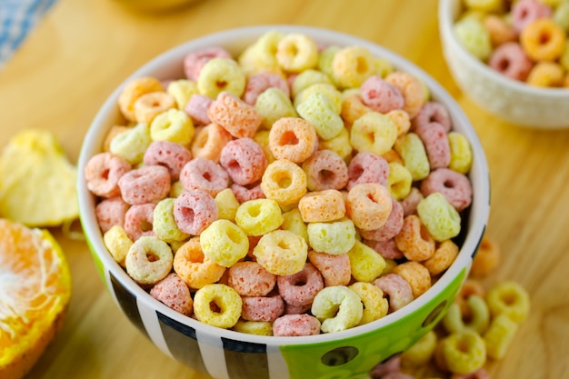 Fiocchi di cereali in una ciotola Concetto di colazione. Cibo con delizioso gusto fruttato e colori fruttati