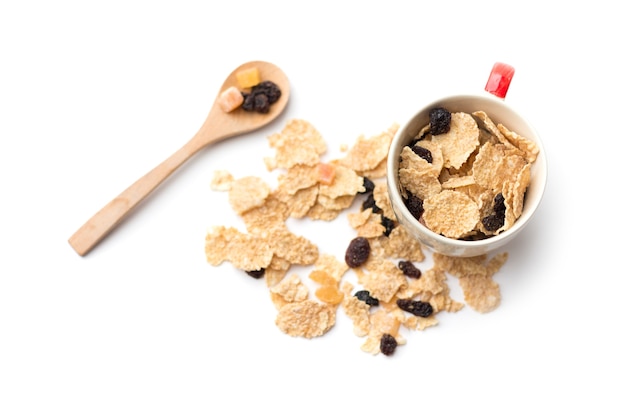 Fiocchi di cereali integrali che hanno mescolato frutti di bosco e uvetta per colazione isolaed su uno spazio bianco