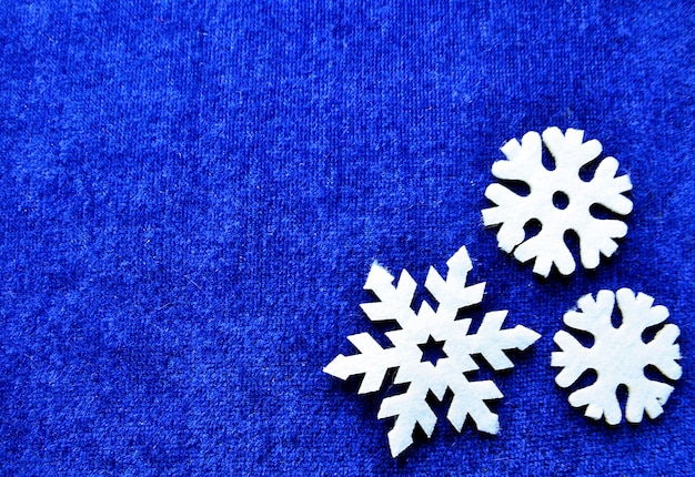 Fiocchi di neve decorativi bianchi su sfondo blu con spazio di copia Concetto di decorazione natalizia