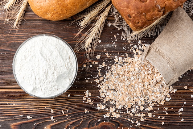 Fiocchi di pane e segale su legno scuro.