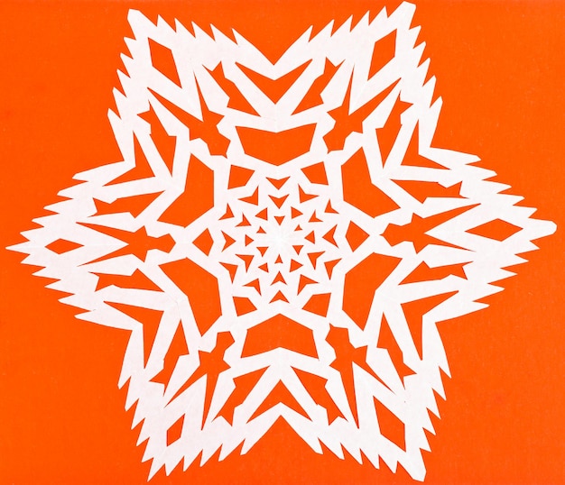 Fiocco di neve bianco su carta arancione
