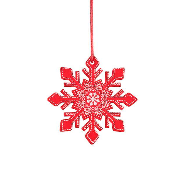 Fiocco di neve di legno rosso d'attaccatura, ornamento rustico dell'albero di Natale isolato su fondo bianco.
