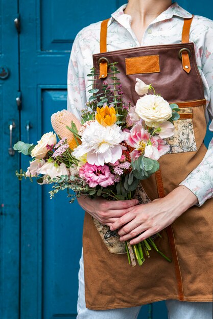 Fioraio con in mano un mazzo di fiori