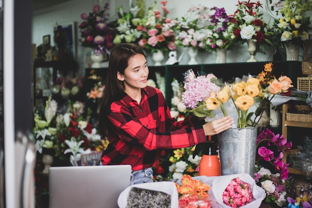 Fioraio fioraio giovane donna nel negozio di fiori