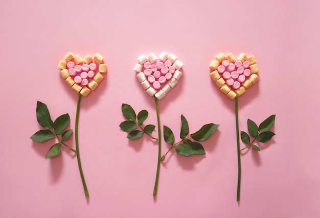 Fiore a forma di un cuore su sfondo rosa.