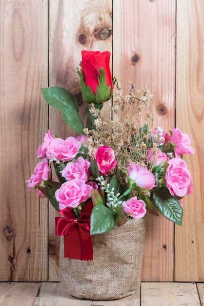 fiore di rosa in vaso vaso, nel tavolo del caffè con fondo in legno