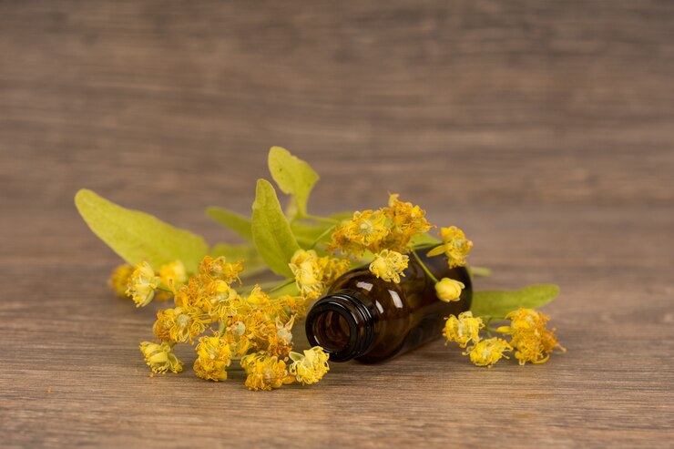 Fiore di tiglio con bottiglia di vetro marrone scuro. Medicina alternativa o concetto di guarigione popolare.