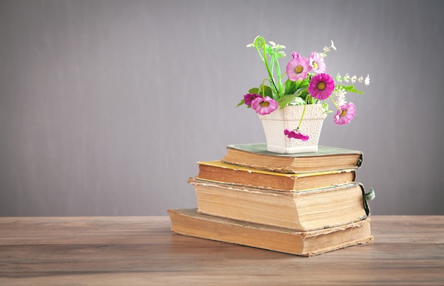 Fiore e libro sul tavolo di legno.