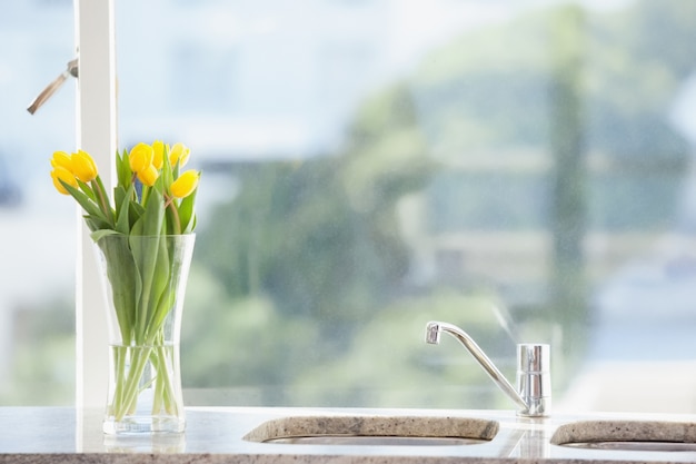 Fiore giallo in un vaso sul lavandino