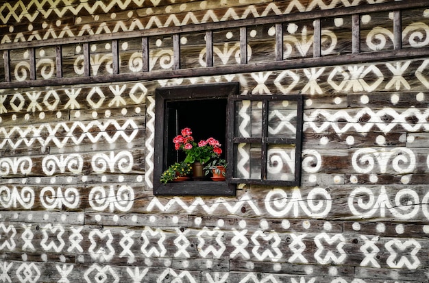 Fiore in vaso alla finestra del cottage in legno