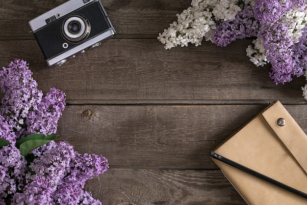 Fiore lilla su fondo di legno rustico con il taccuino per la vista superiore del messaggio di saluto