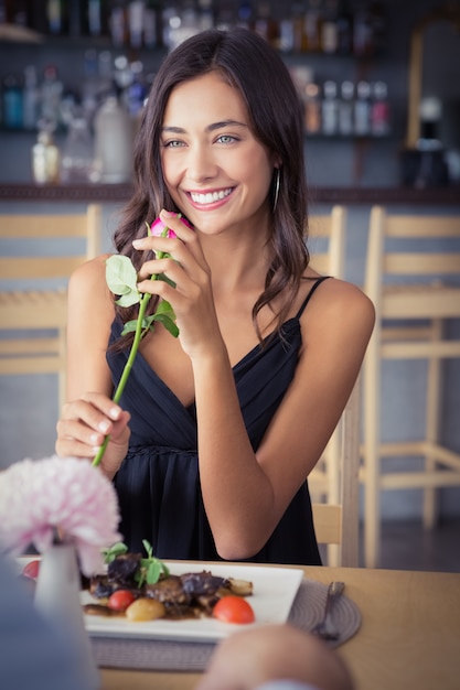 Fiore rosa e sorridere della bella tenuta della donna