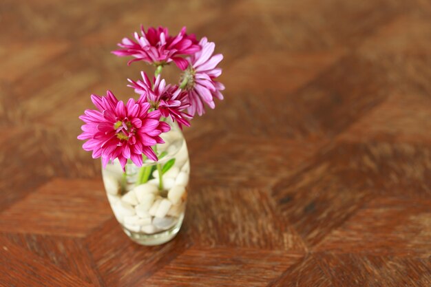 Fiore viola in vetro sul tavolo di legno