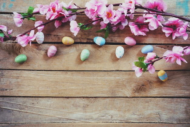 Fiori artificiali e uovo di Pasqua del fiore di ciliegia su fondo di legno d&#39;annata con lo spazio della copia.