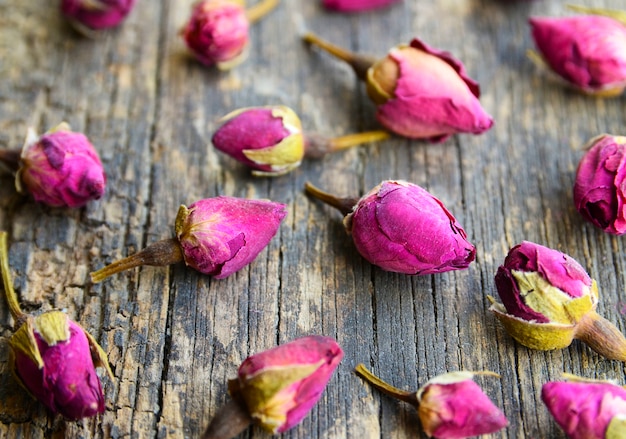 Fiori asciutti dei germogli rosa sulla vecchia tavola di legno