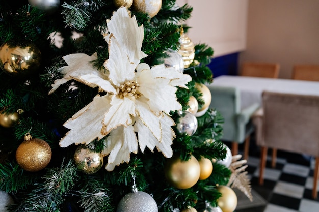 Fiori bianchi decorativi sull'albero di Natale. Giocattoli originali sull'abete artificiale. Nuovo anno.