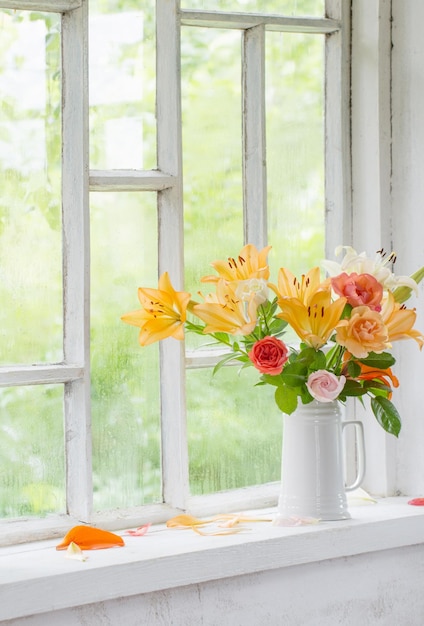 Fiori d'estate in vaso sulla finestra di sfondo con gocce d'acqua