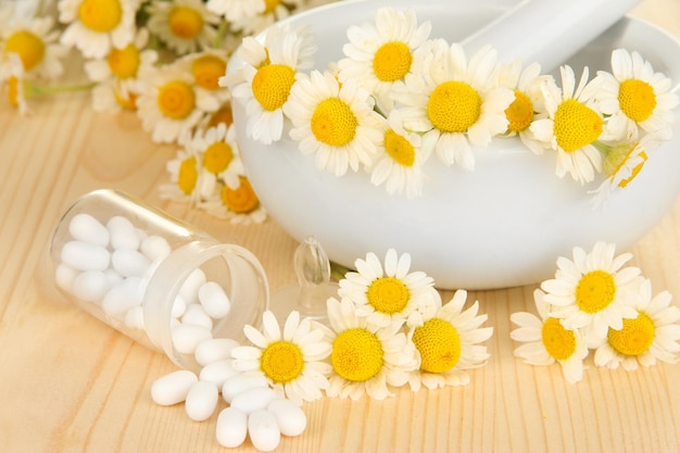 Fiori di camomilla medicinale su tavola di legno