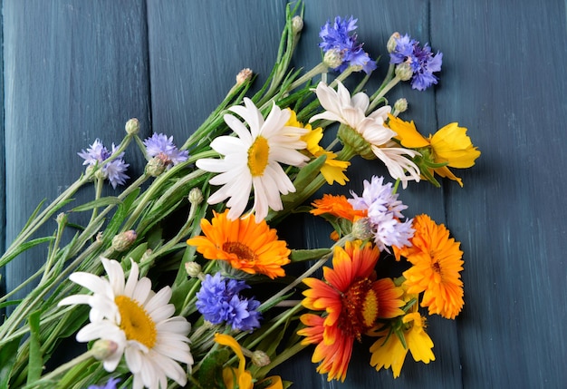 Fiori di campo luminosi sul primo piano della tavola di legno