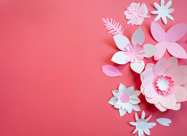 Fiori di carta con sfondo rosa e fiore bianco a destra.