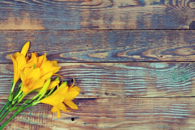 Fiori di giglio giallo su sfondo di legno