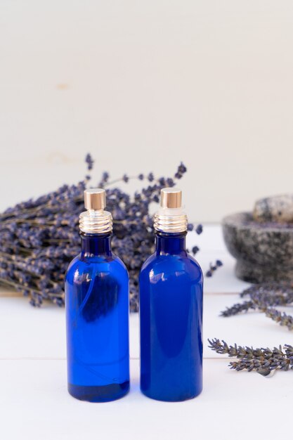 Fiori di lavanda e olio di lavanda in due bottiglie blu