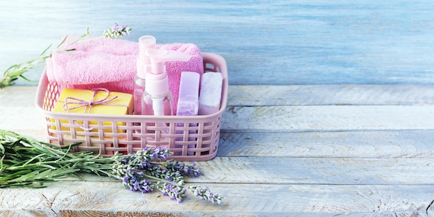 Fiori di lavanda freschi sapone spray e asciugamano in un cestino su un tavolo di legno spa cosmetici naturali