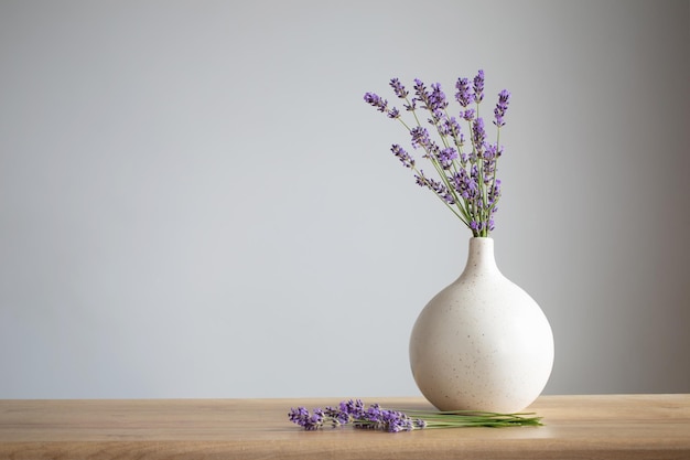 Fiori di lavanda in vaso di ceramica su sfondo grigio