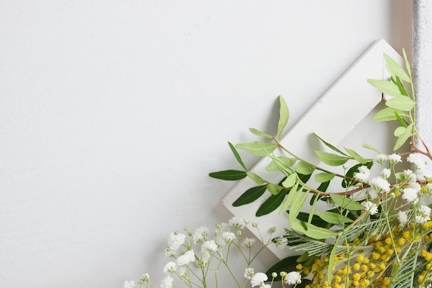 Fiori di mimosa primaverili e cornice in legno su sfondo grigio, spazio copia piatto