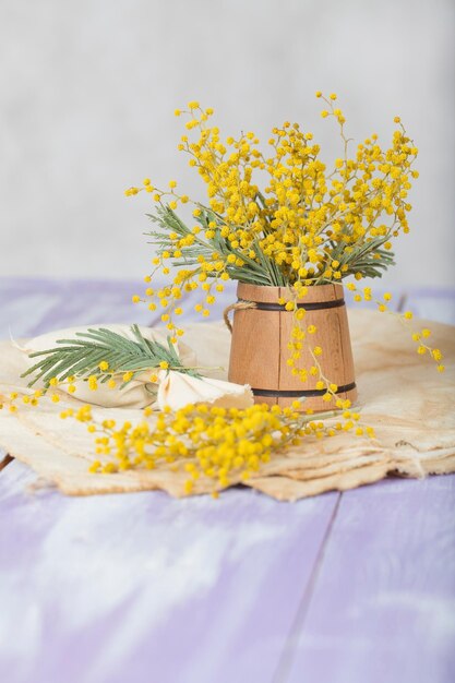 Fiori di mimosa su un mini secchio di legno. Avvicinamento