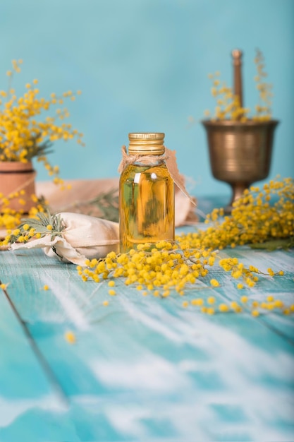 Fiori di mimosa su una superficie di legno. Primo piano Tonico all'estratto di fiori di mimosa. Avvicinamento