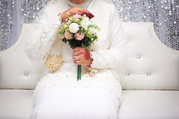 Fiori di nozze Donna che tiene bouquet rosso con le mani il giorno del matrimonio Messa a fuoco selettiva