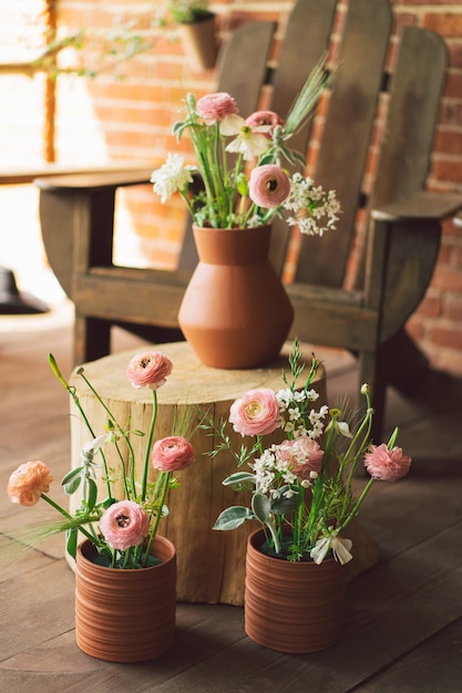 Fiori di ranuncolo in vasi di argilla sul terrazzo bellissimi fiori in un vaso
