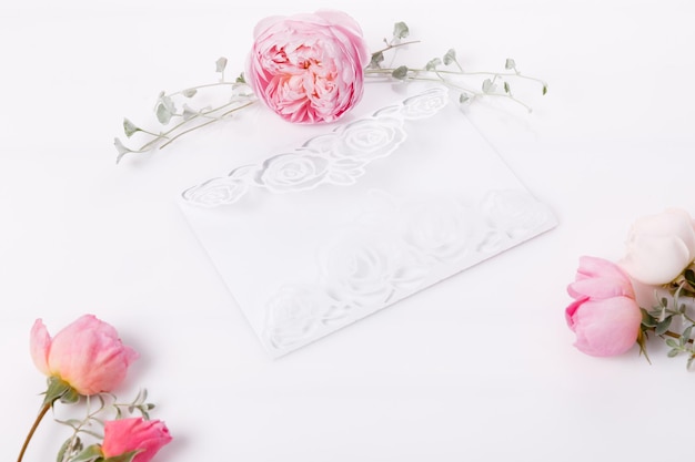 Fiori di rosa rosa e biglietto di auguri con fiori recisi su carta, stile adorabile