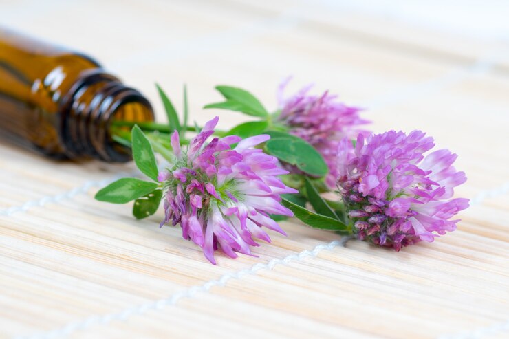 Fiori di trifoglio con bottiglia di vetro su una stuoia di bambù