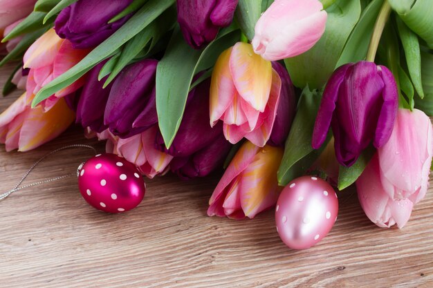 Fiori di tulipano rosa e viola con le uova di Pasqua