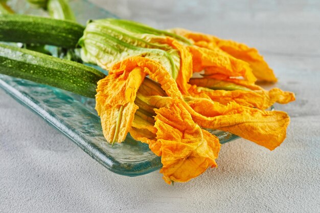 Fiori di zucchini o zucchini pronti a cuocere con formaggio parmesano in casserola aperitivo italiano