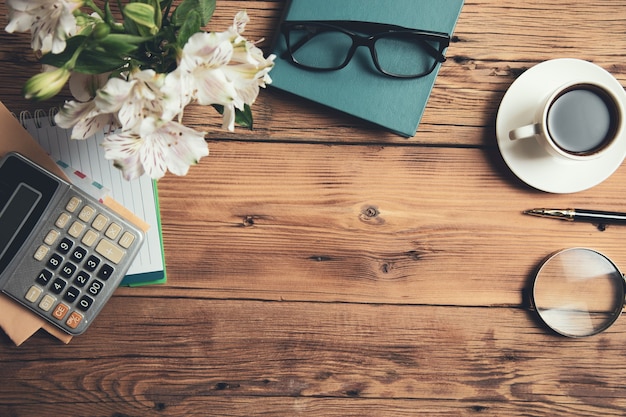 Fiori e calcolatrice con caffè sul tavolo