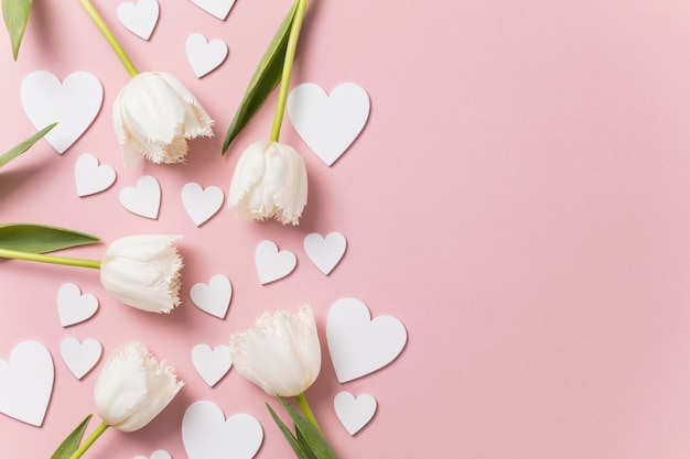 Fiori e cuori bianchi su sfondo rosa pastello