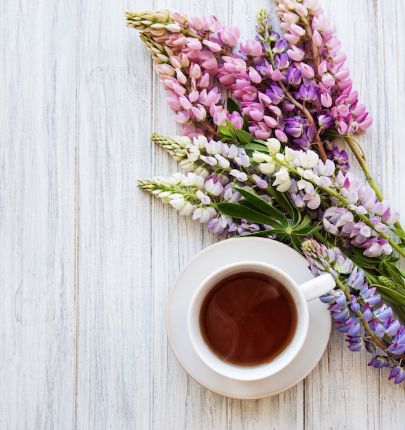 Fiori e tazza di tè rosa e porpora del lupino